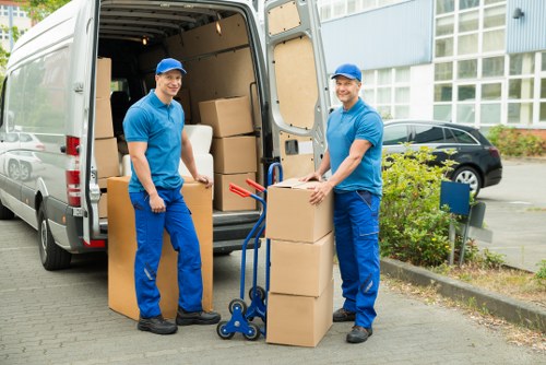 Professional movers carrying furniture during a Morden relocation
